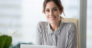 Portrait of smiling beautiful millennial businesswoman or CEO looking at camera, happy female boss posing making headshot picture for company photoshoot, confident successful woman at work